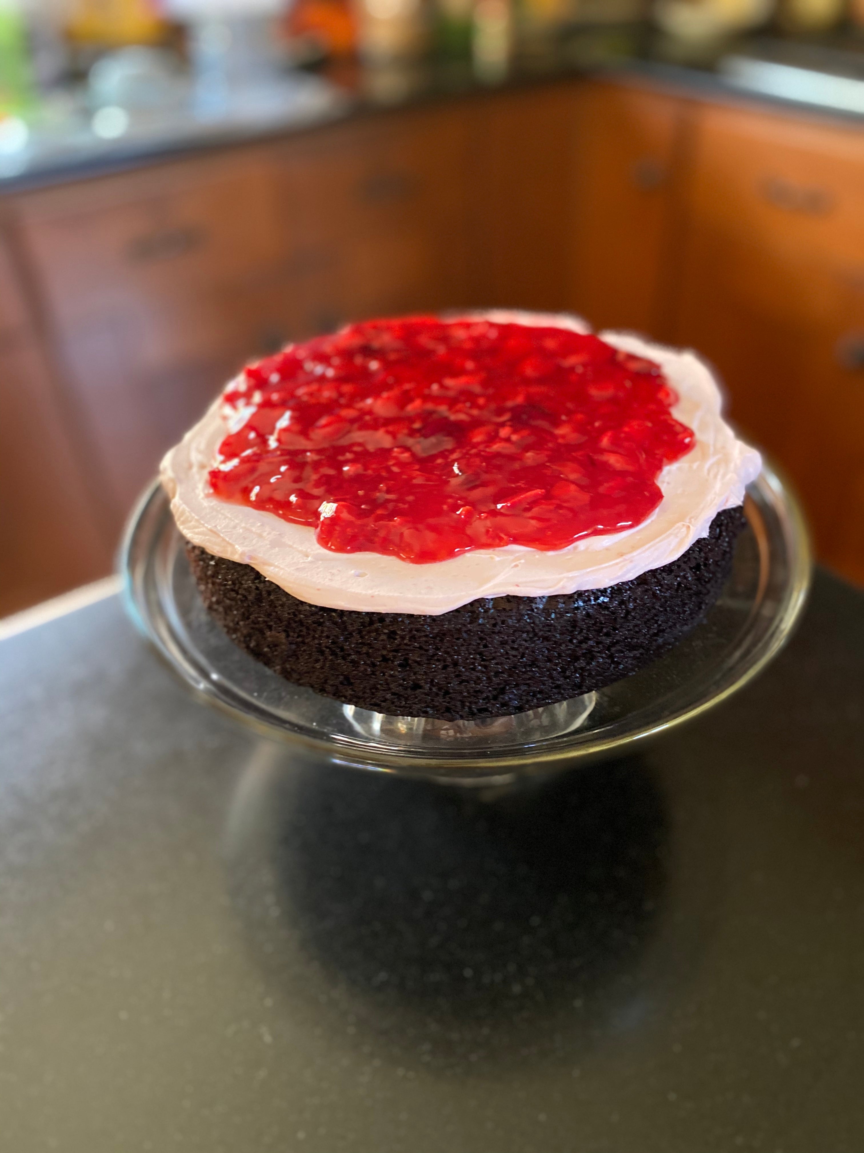 inside view of Cherry Bomb Cake showing a layer of moist chocolate cake with a layer of fresh Cherry puree' on top of Cherry whipped cream cheese frosting