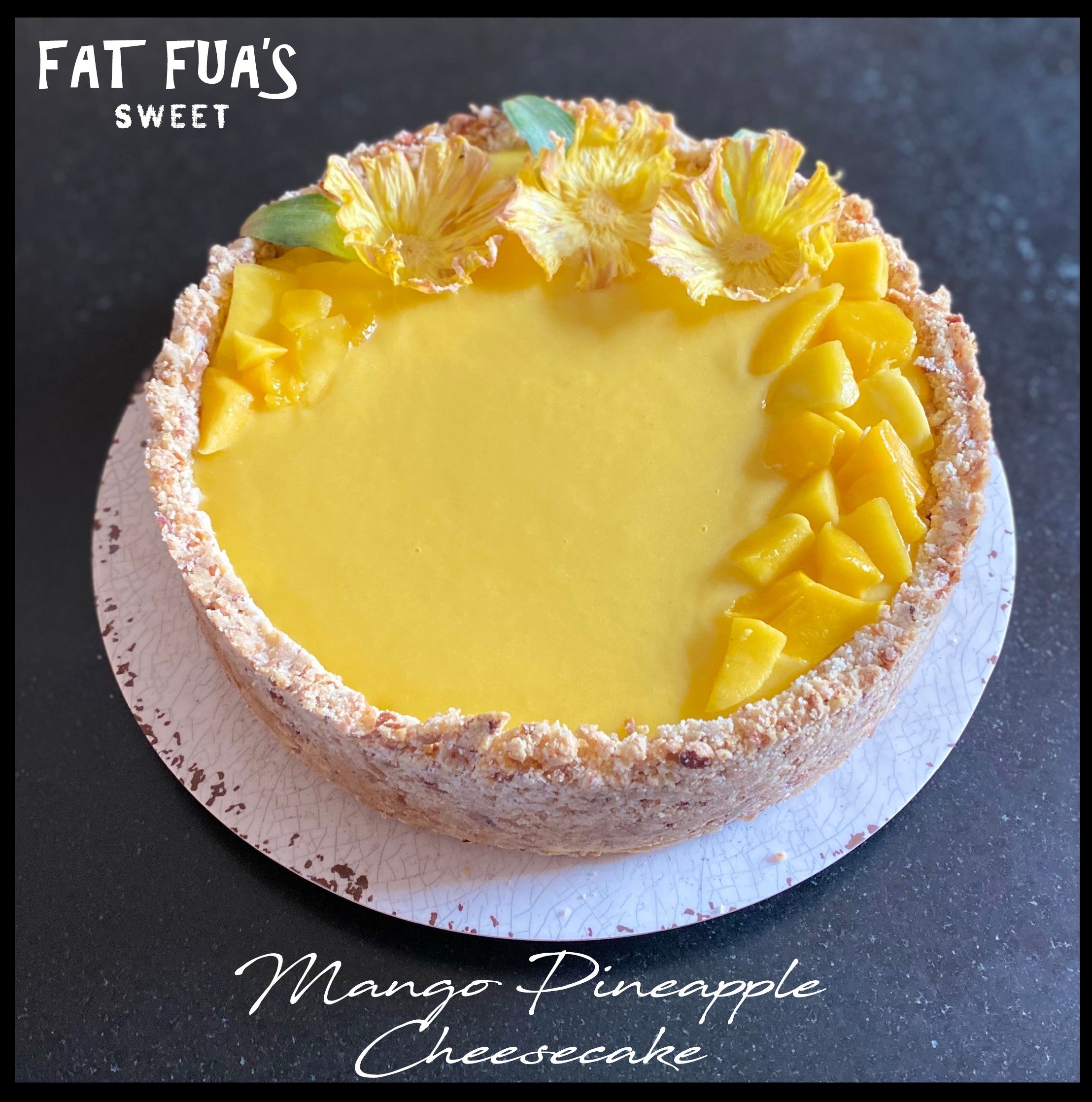 Tropical Cheesecake Made from Scratch, Coconut Almond Shortbread Crust with Mango/Pineapple Cream Cheese Filling. Topped with Mango/Pineapple Curd a pile of sliced Mangos and Handmade Pineapple Floral Garnish.