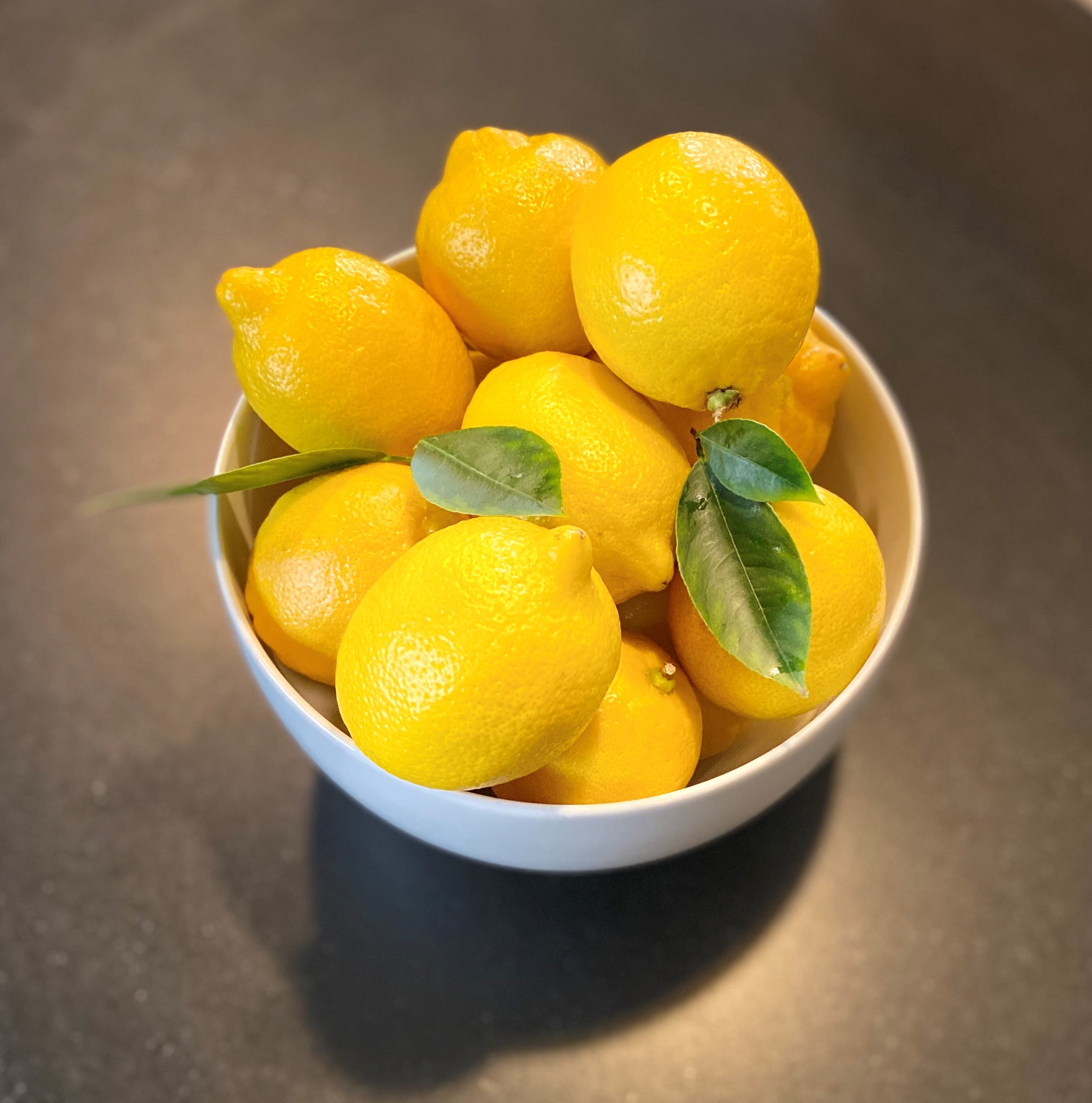 White bowl of fresh lemons